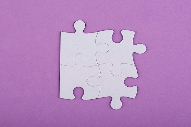Pezzi di puzzle bianchi vista dall'alto e sfondo viola