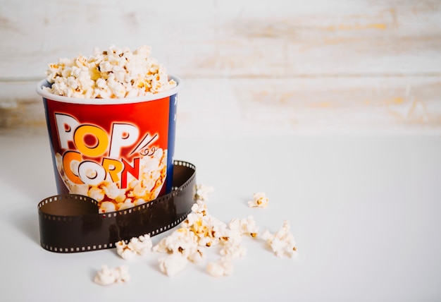 Pezzo di film vicino al secchio del popcorn