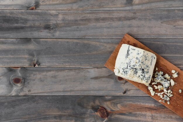 Pezzo di formaggio Roquefort su tavola di legno sopra la scrivania