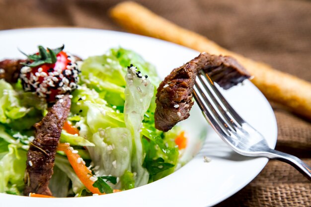 pezzo di insalata di carne sulla vista laterale folk