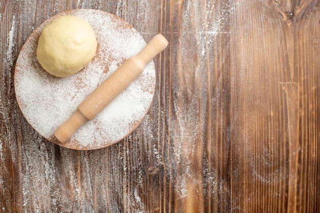 Pezzo di pasta cruda vista dall'alto con farina sulla farina di farina da scrivania in legno cuocere la pasta