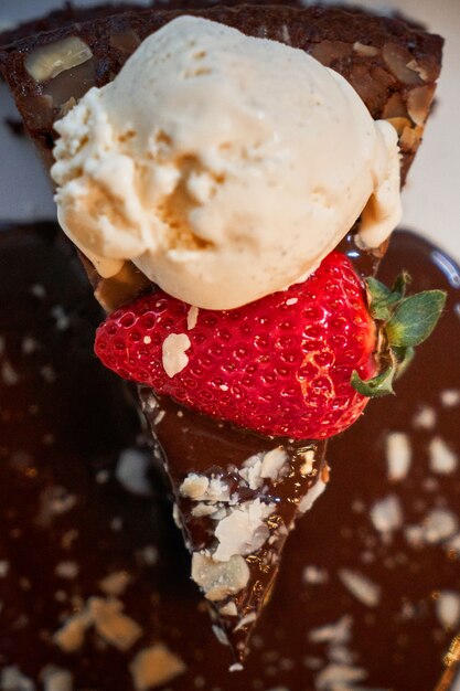 Pezzo di torta al cioccolato con fragole e gelato