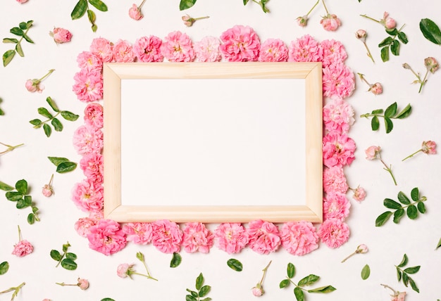 Photo frame tra set di fiori rosa e foglie verdi