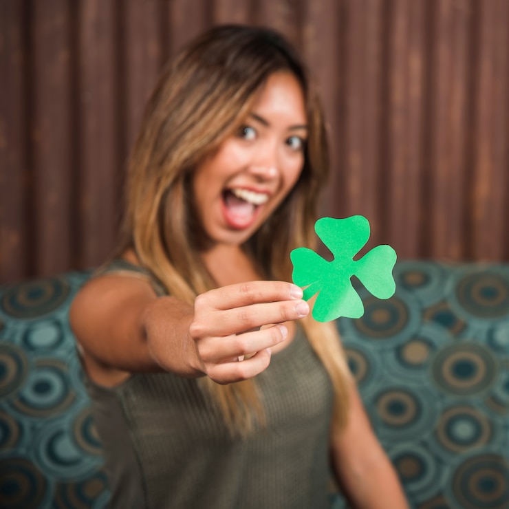 Foto gratuito piangere donna felice che tiene il trifoglio di carta verde