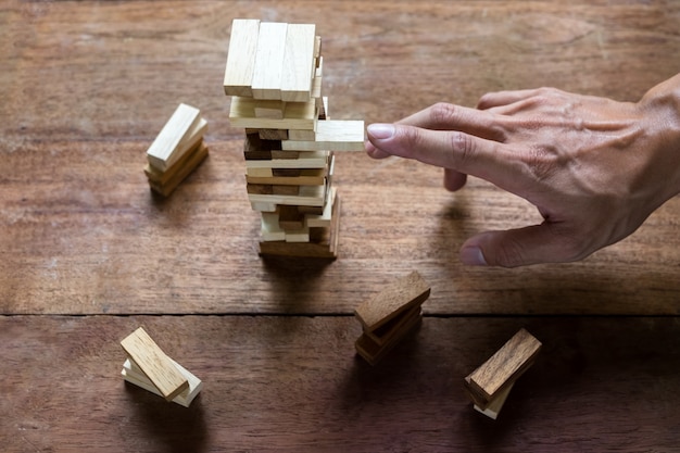 Pianificazione, rischio e strategia nei settori degli affari, degli imprenditori e degli ingegneri che fanno un blocco di legno su una torre.