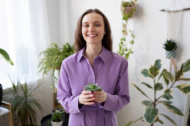 Pianta della holding della donna di smiley del colpo medio