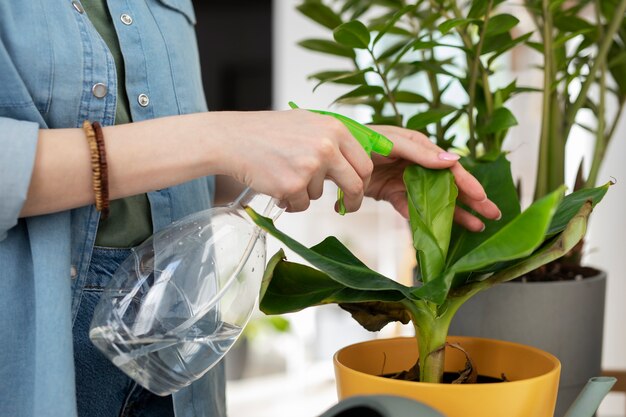 Pianta di irrigazione della giovane donna di vista laterale