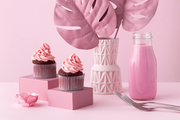 Piante di monstera e disposizione di cupcakes rosa