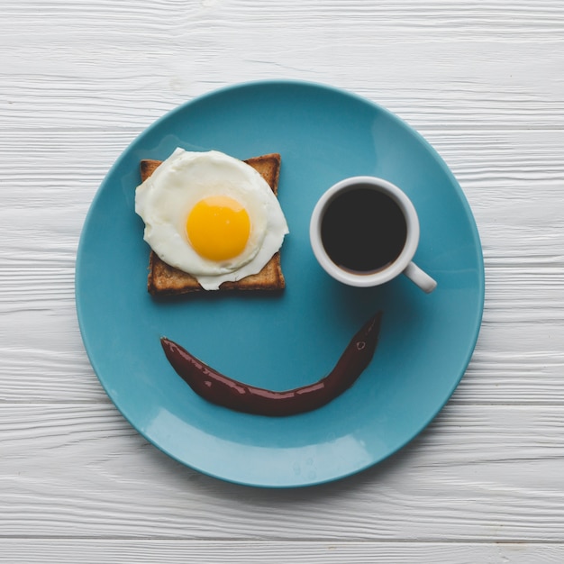 Piastra con caffè e uovo fritto