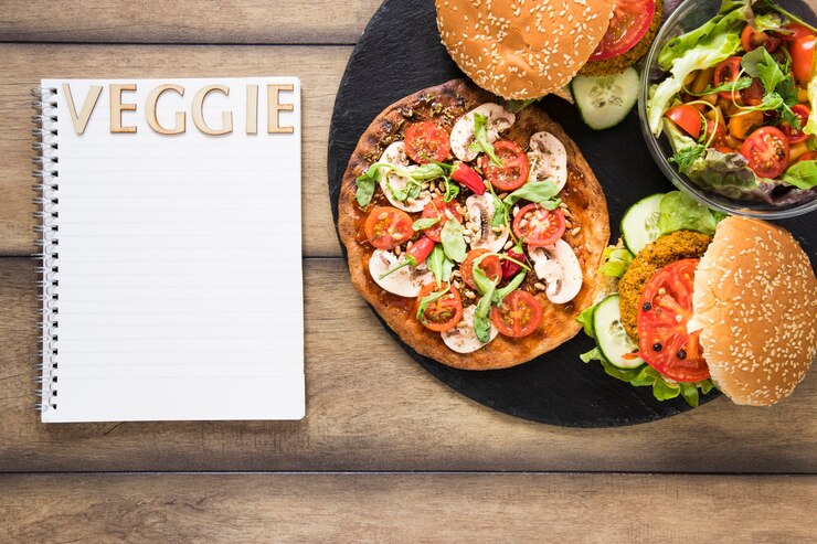 Foto gratuito piastra con delizioso cibo vegetariano accanto al notebook