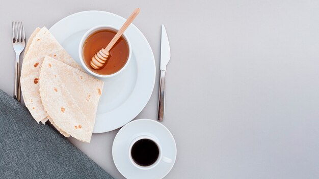 Piastra vista dall'alto con miele e tortilla