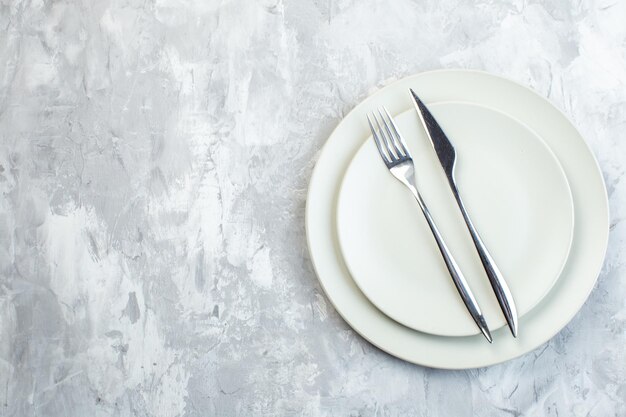 Piatti bianchi vista dall'alto con forchetta e coltello su superficie bianca colore pasto cucina orizzontale vetro cibo