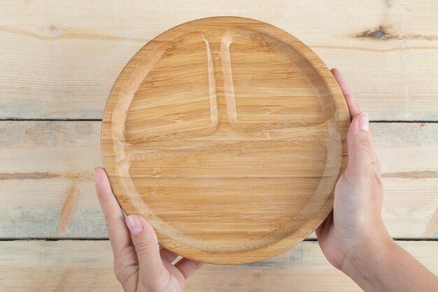 Piatti da colazione in legno con all'interno pezzi intagliati.