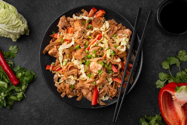 Piatto asiatico sulla piastra con bacchette e verdure
