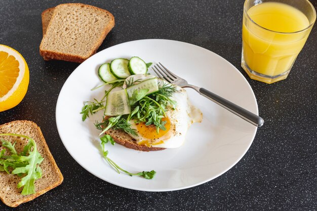 Piatto bianco con uova fritte e succo d'arancia