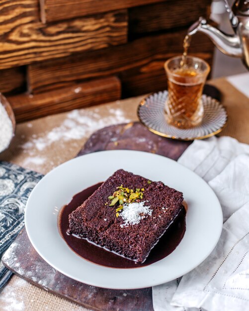 Piatto bianco interno saporito del choco di vista frontale insieme a tè caldo sulla superficie marrone