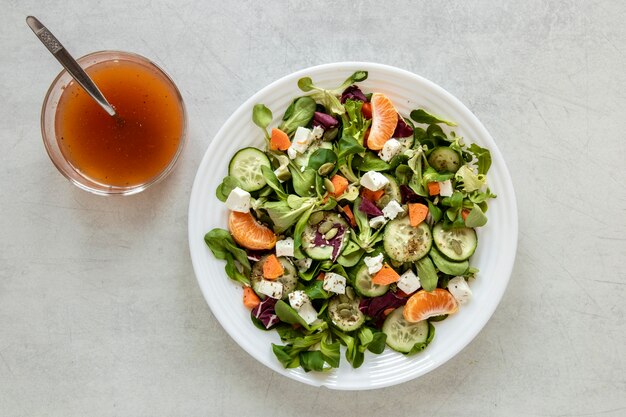 Piatto con insalata e ciotola con salsa