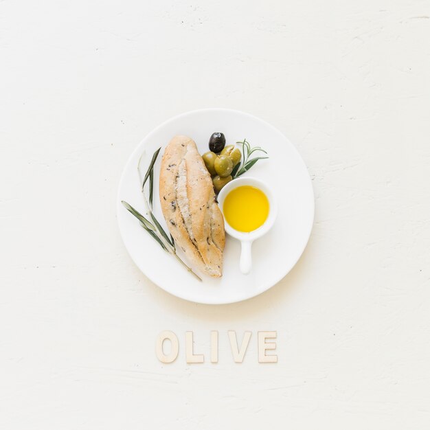 Piatto con olive e olio di pane con parola oliva