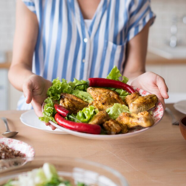 Piatto dell'alimento della tenuta della donna del primo piano