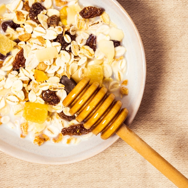 Piatto di avena e mestolo di legno miele