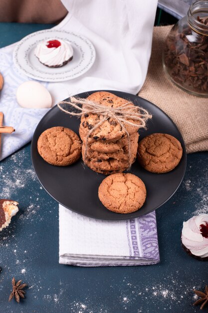 Piatto di caramelle e due torte e biscotti con cannella