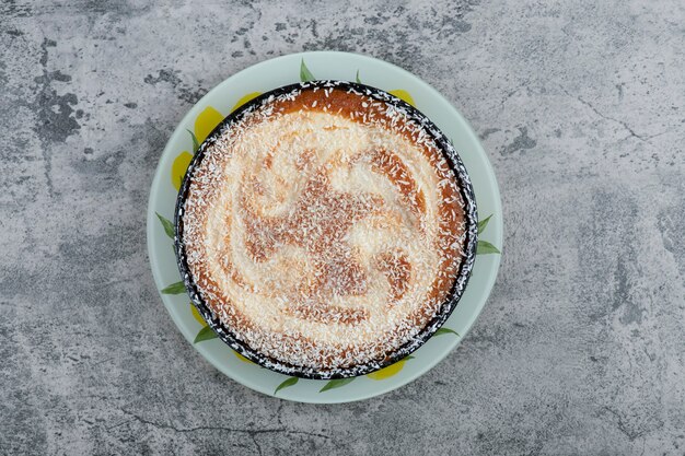 Piatto di deliziosa torta in polvere con zucchero posto su un tavolo di legno.