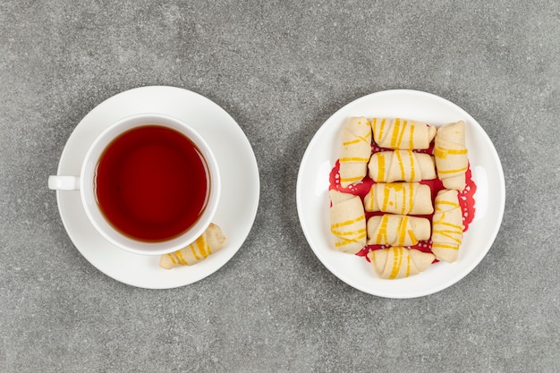 Piatto di deliziosi biscotti e tazza di tè sulla superficie in marmo