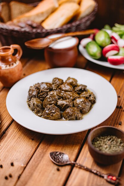 Piatto di dolma di foglie di vite azera servito con yogurt e insalata