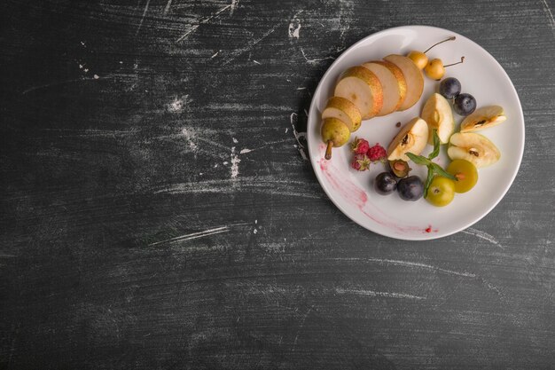 Piatto di frutta bianca isolato su sfondo nero