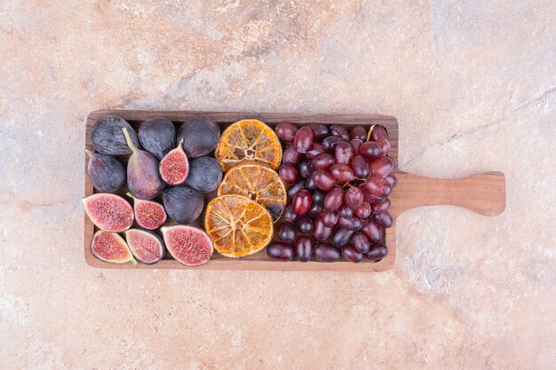 Piatto di frutta con cornioli, fichi e fette d'arancia