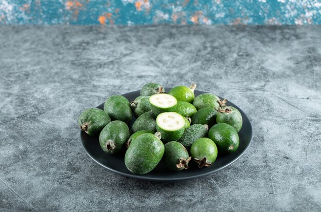 Piatto di frutti di feijoa su tavola di marmo. Foto di alta qualità