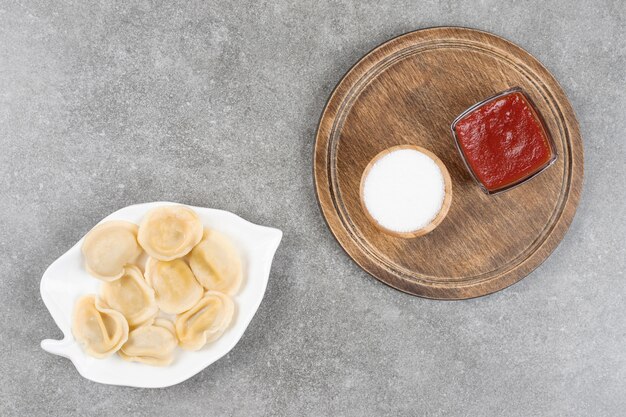 Piatto di gnocchi e salse sulla superficie in marmo