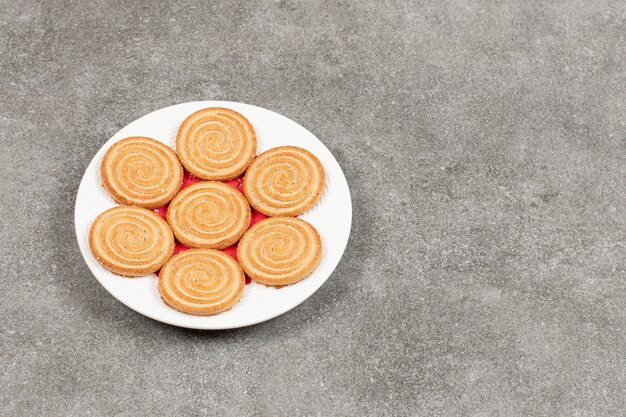 Piatto di gustosi biscotti rotondi sulla superficie in marmo