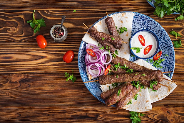 Piatto di kebab tradizionale turco e arabo Ramadan mix. Kebab adana, pollo, agnello e manzo su pane lavash con salsa. Vista dall'alto