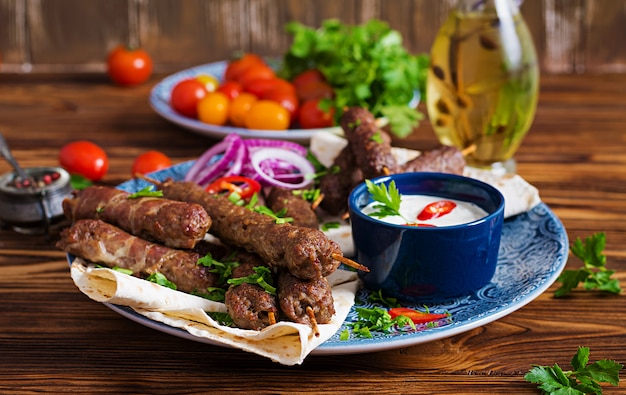 Piatto di kebab tradizionale turco e arabo Ramadan mix. Kebab adana, pollo, agnello e manzo su pane lavash con salsa. Vista dall'alto