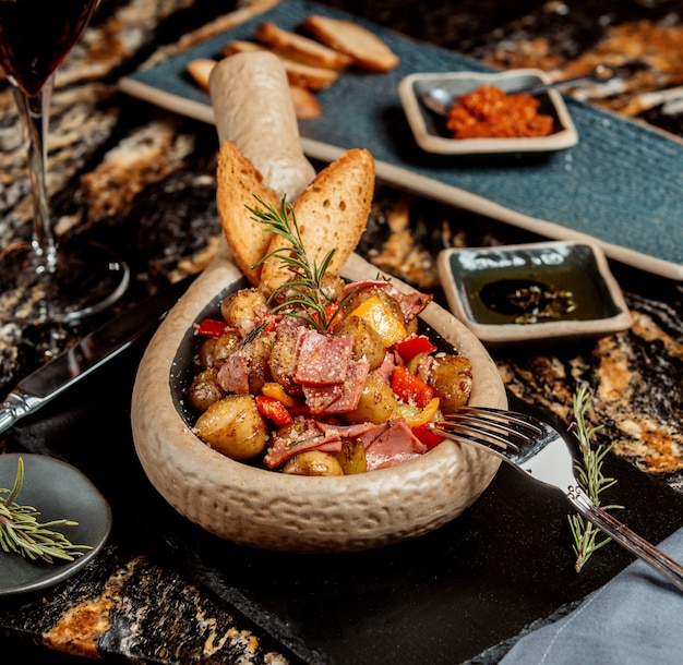 Piatto di patate con salame rosso e peperone giallo