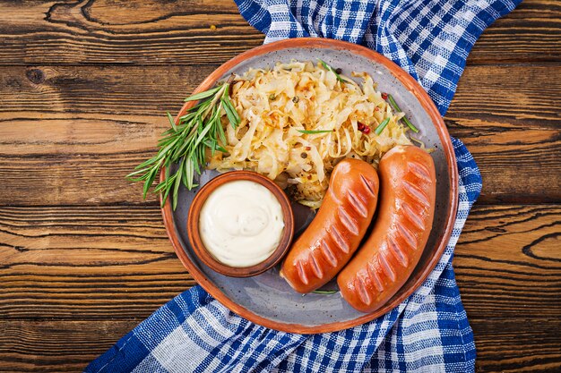 Piatto di salsicce e crauti sul tavolo di legno. Menu tradizionale dell'Oktoberfest. Disteso. Vista dall'alto.