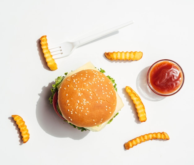 Piatto disteso di hamburger con patatine fritte e ketchup