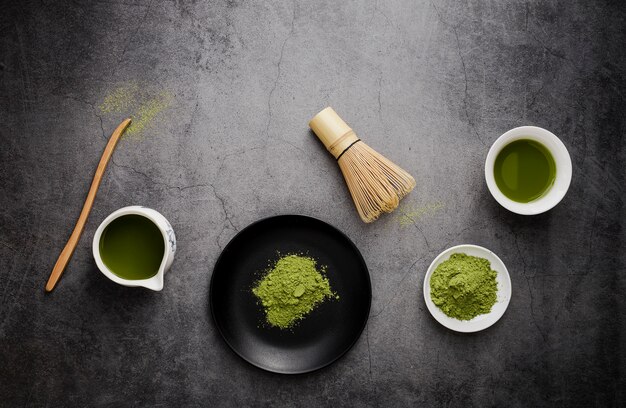 Piatto disteso di tè matcha con frusta e piatto di bambù