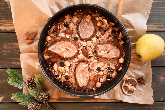 Piatto disteso di torta con fettine di pera e noci