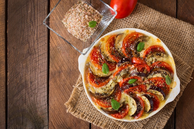 Piatto gratinato preparato melanzane crude con mozzarella e pomodori