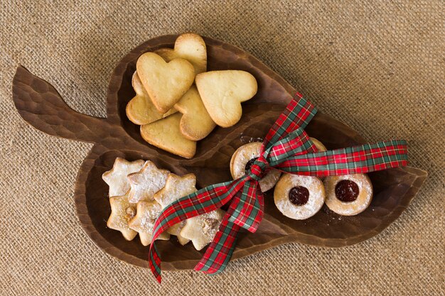 Piatto in legno con diversi biscotti sul tavolo