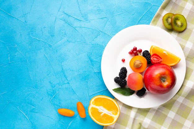 Piatto piano di bacche fresche e frutta con copyspace