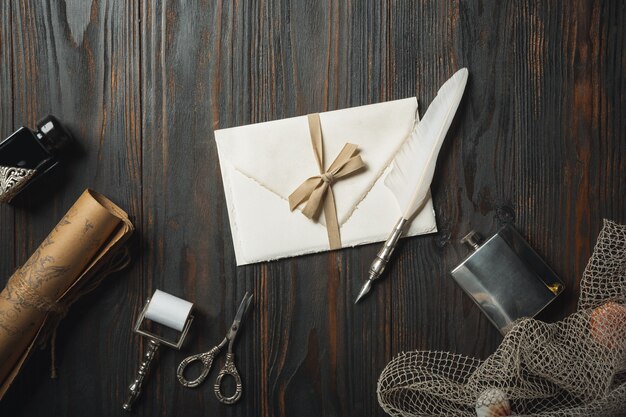 Piatto vecchio stile giaceva con lettere scrivendo accessori sul tavolo di legno scuro