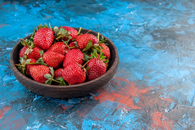 Piatto vista frontale con fragole fresche e gustose frutti maturi su sfondo blu foto colore albero di bacche rosso estate selvaggia