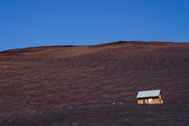 Piccola casa isolata su un grande campo sotto il cielo azzurro