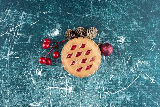 Piccola gustosa torta alla frutta con palline di Natale e pigne. Foto di alta qualità