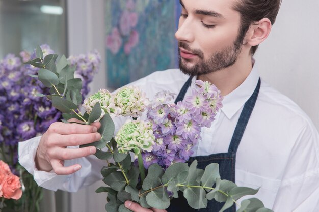 Piccola impresa. Fiorista maschio nel negozio di fiori. fare decorazioni e arrangiamenti