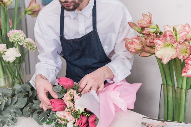 Piccola impresa. Fiorista maschio nel negozio di fiori. fare decorazioni e arrangiamenti