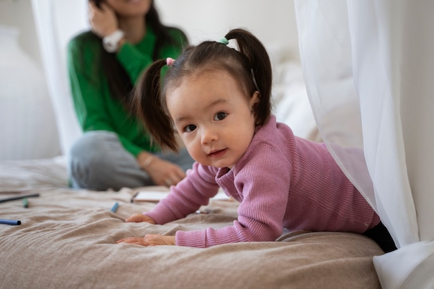 Piccola ragazza asiatica che trascorre del tempo a casa con sua madre